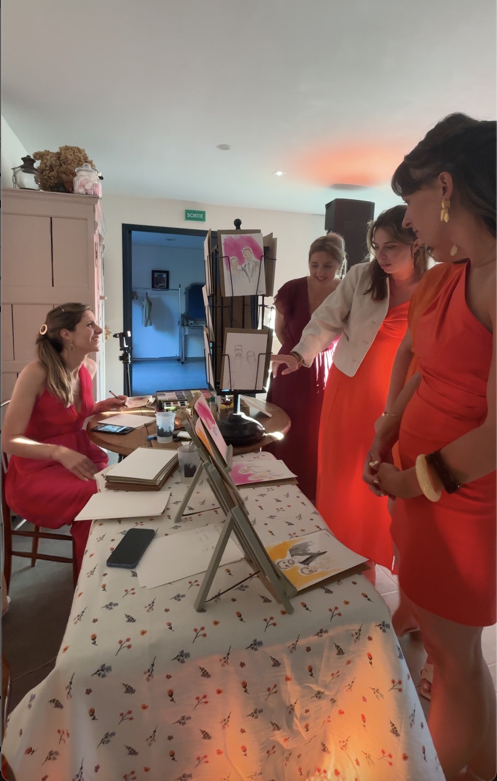 Des invitées découvrent les portraits réalisés sur mesure pendant un mariage
